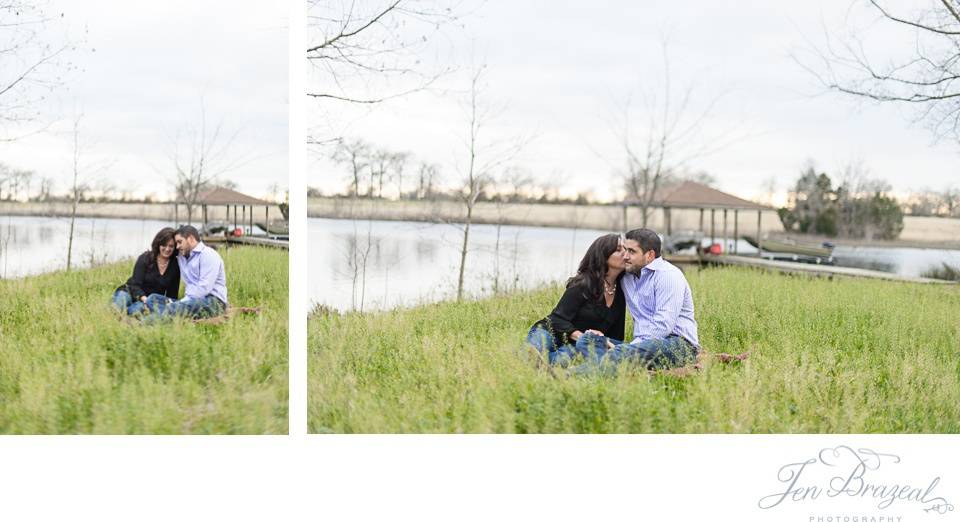 engaged couple kissing in the grass